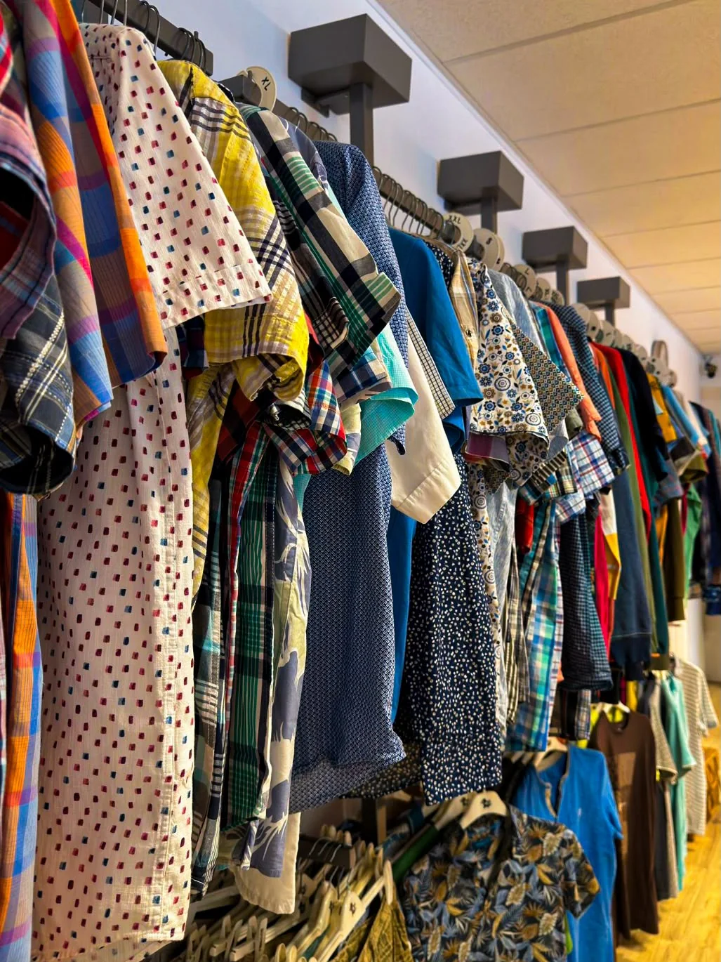 Kledingrekken met kleurrijke kleding in Kledingbank Maxima Veendam